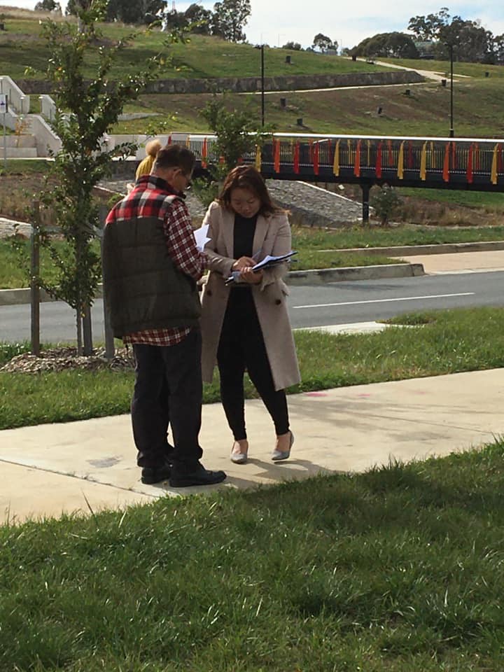 Photo shows Serene signing paperwork with two people.